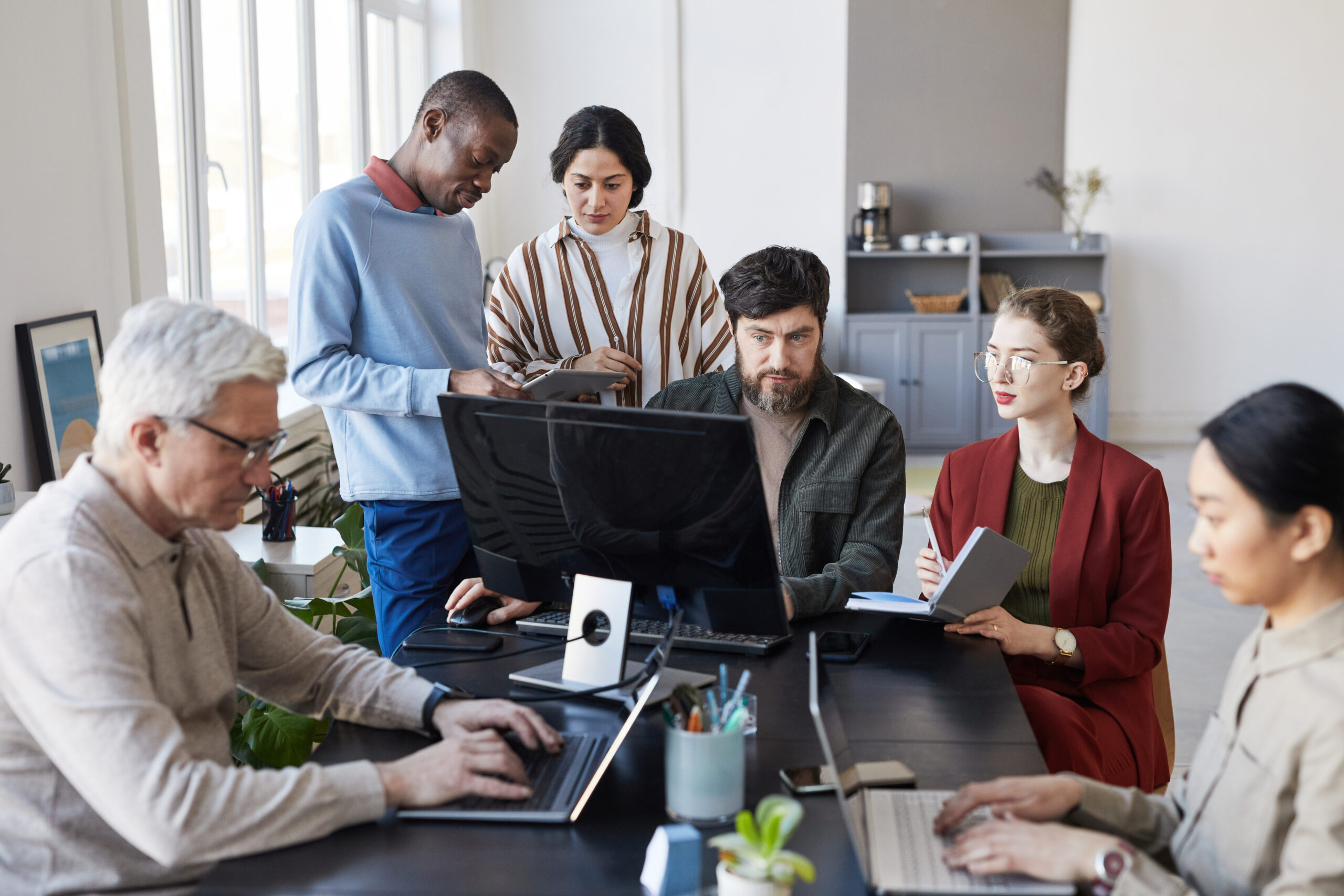 A group of marketing professionals working collaboratively in their marketing jobs.